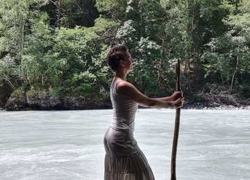 Bernadette Kögler am Inn Profilfoto von Bernadette Kögler mit Stock in der Hand am Ufer vom Inn Fluss in Tirol