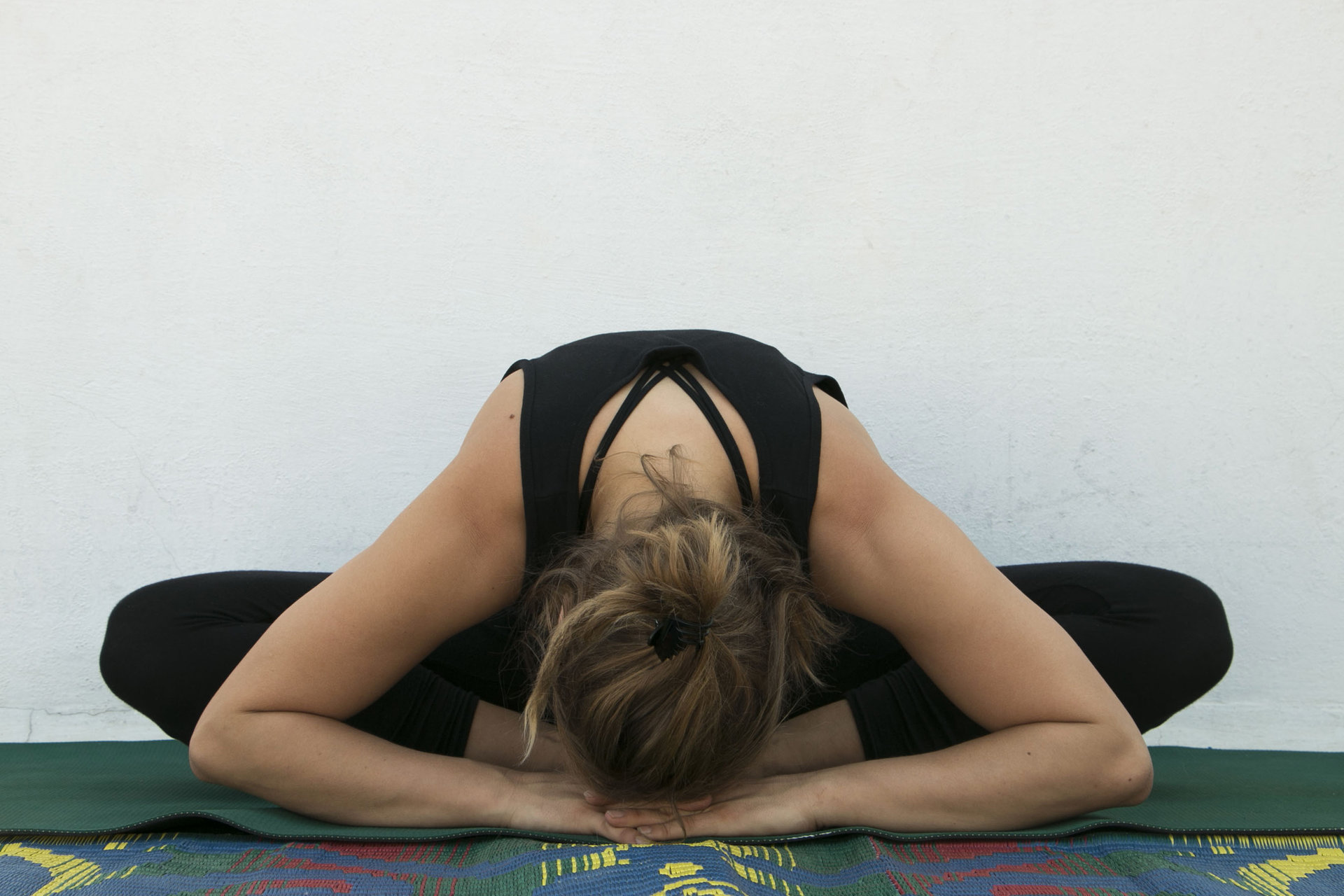 Kris Rohacek in einer Yoga Position mit dem Kopf am Boden und in Lotussitz